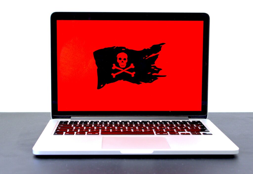 Laptop computer displaying a black pirate flag over a red screen